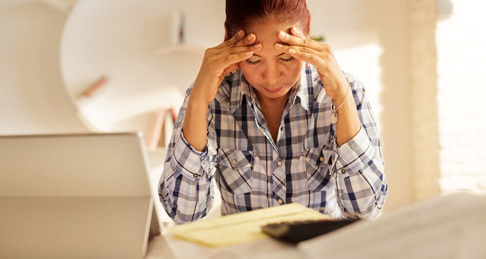 Tensed lady holding forehead with both hands