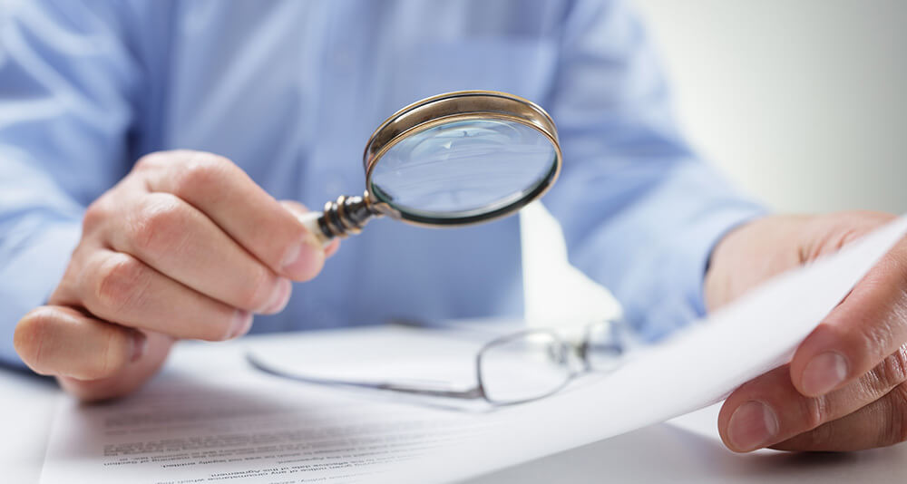 A Probate attorney reading contract fine print with magnifying glass