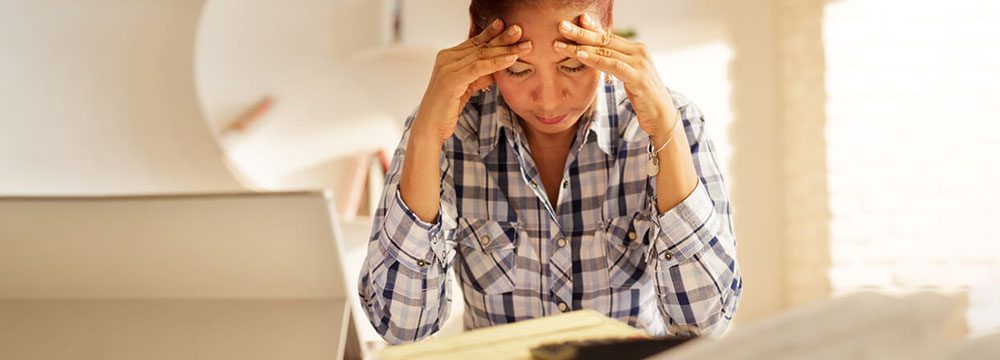 Tensed lady holding forehead with both hands