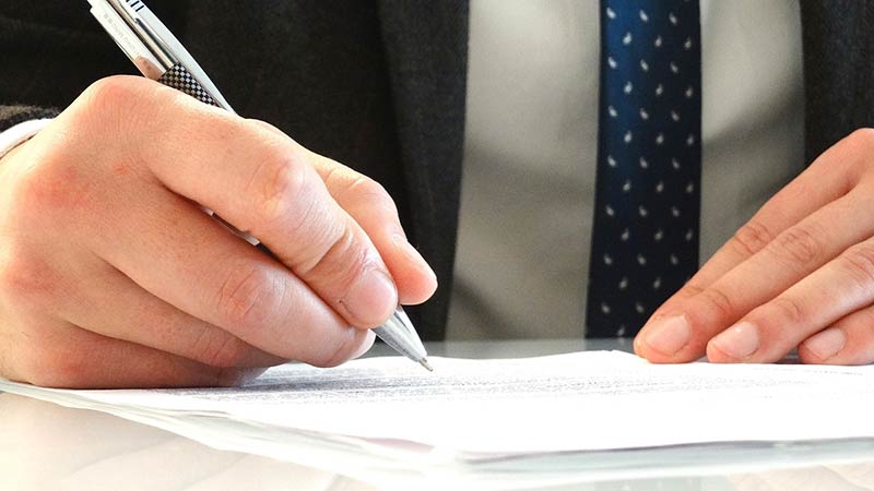 hands signing paperwork