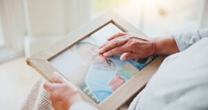 hands touching a picture frame with photo of loved one