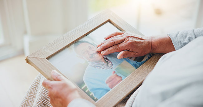 hands touching a picture frame with photo of loved one